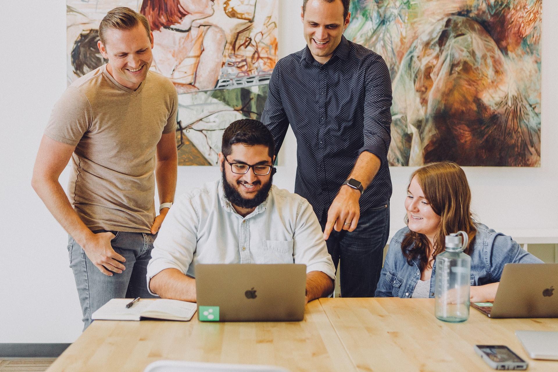 Equipo colaborando alrededor de una mesa de trabajo